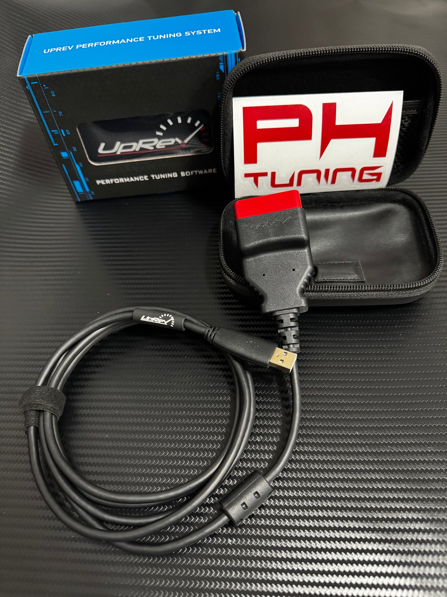 Close-up view of UpRev Remote Tuning Kit’s OBD‑II connector and robust wiring, branded for PowerHouse tuning.